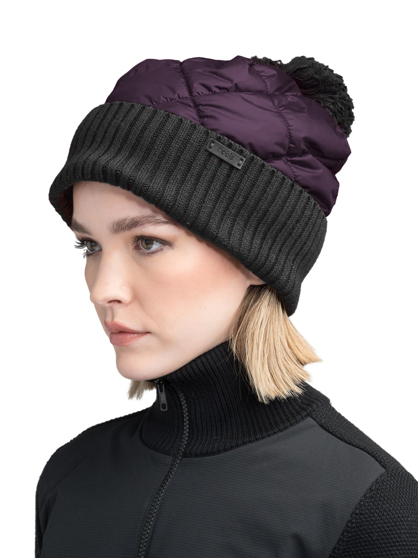 Lany Unisex Hybrid Pom Beanie in an extra fine merino wool blend and premium cire technical taffeta fabrication, rib knit cuff with leather Nobis wordmark detailing, quilted body, and plush pom-pom finish, in Potent Purple