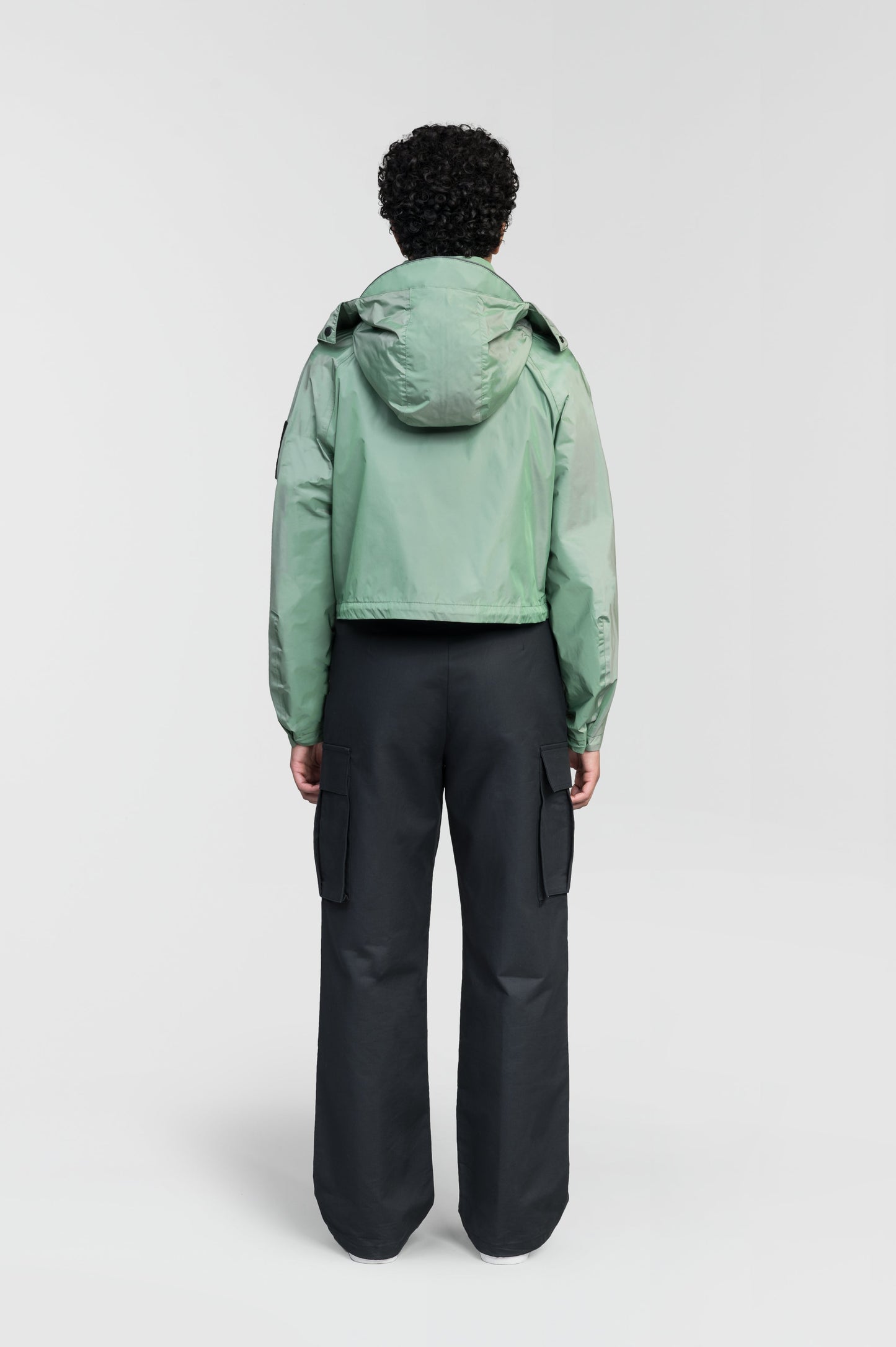 Viva Women's Performance Cropped Jacket in waist length, premium iridescent fabrication, removable hood with peak, adjustable hood draw cords and toggle, 2-way branded zipper at centre front, oversized magnetic closure flap pockets at chest with side entry, interior adjustable draw cord at hem, large interior zipper pocket, and adjustable snap cuffs, in Comfrey