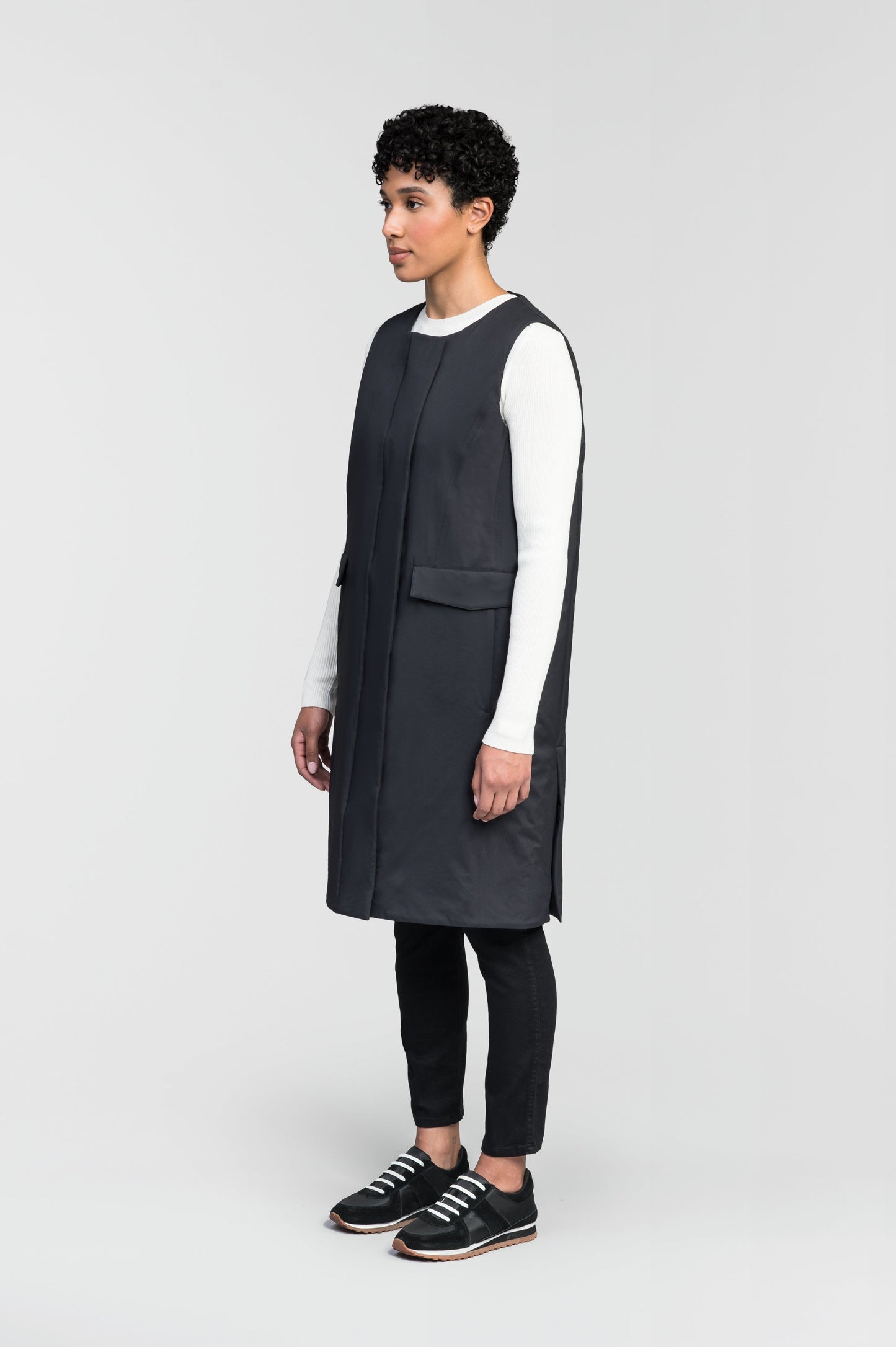 Brexton Women's Tailored Long Mid Layer Vest in knee length, centre front wind flap, flap closure waist pocket with additional side entry storage, single vent on back bottom hem, in Black