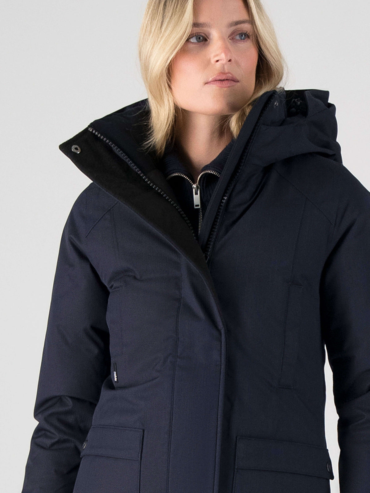 Women's down filled parka that sits just below the hip with a clean look and two hip patch pockets in Navy