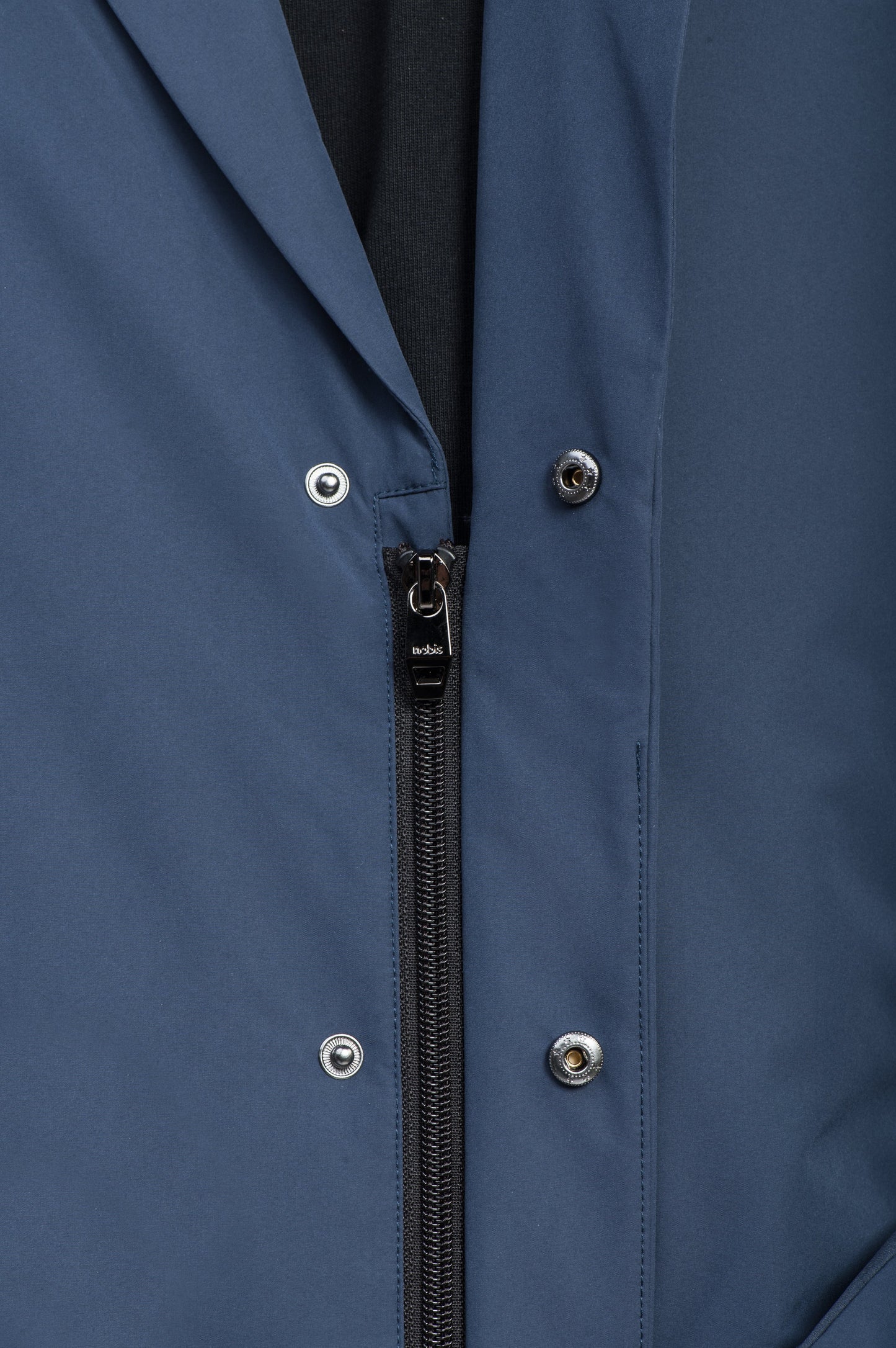 Cody Men's Tailored Travel Blazer in 3-ply micro denier and stretch nylon fabrication with DWR coating, Primaloft Gold Insulation Active+, hidden two-way zipper at centre front with snap closure placket, three invisible exterior zipper pockets, double back pleats, and hidden snap placket at cuffs, in Marine