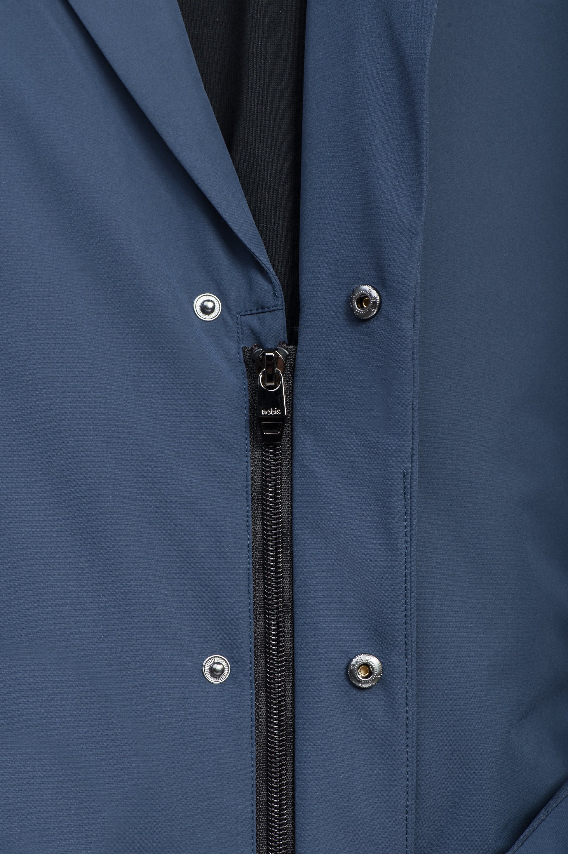 Cody Men's Tailored Travel Blazer in 3-ply micro denier and stretch nylon fabrication with DWR coating, Primaloft Gold Insulation Active+, hidden two-way zipper at centre front with snap closure placket, three invisible exterior zipper pockets, double back pleats, and hidden snap placket at cuffs, in Marine