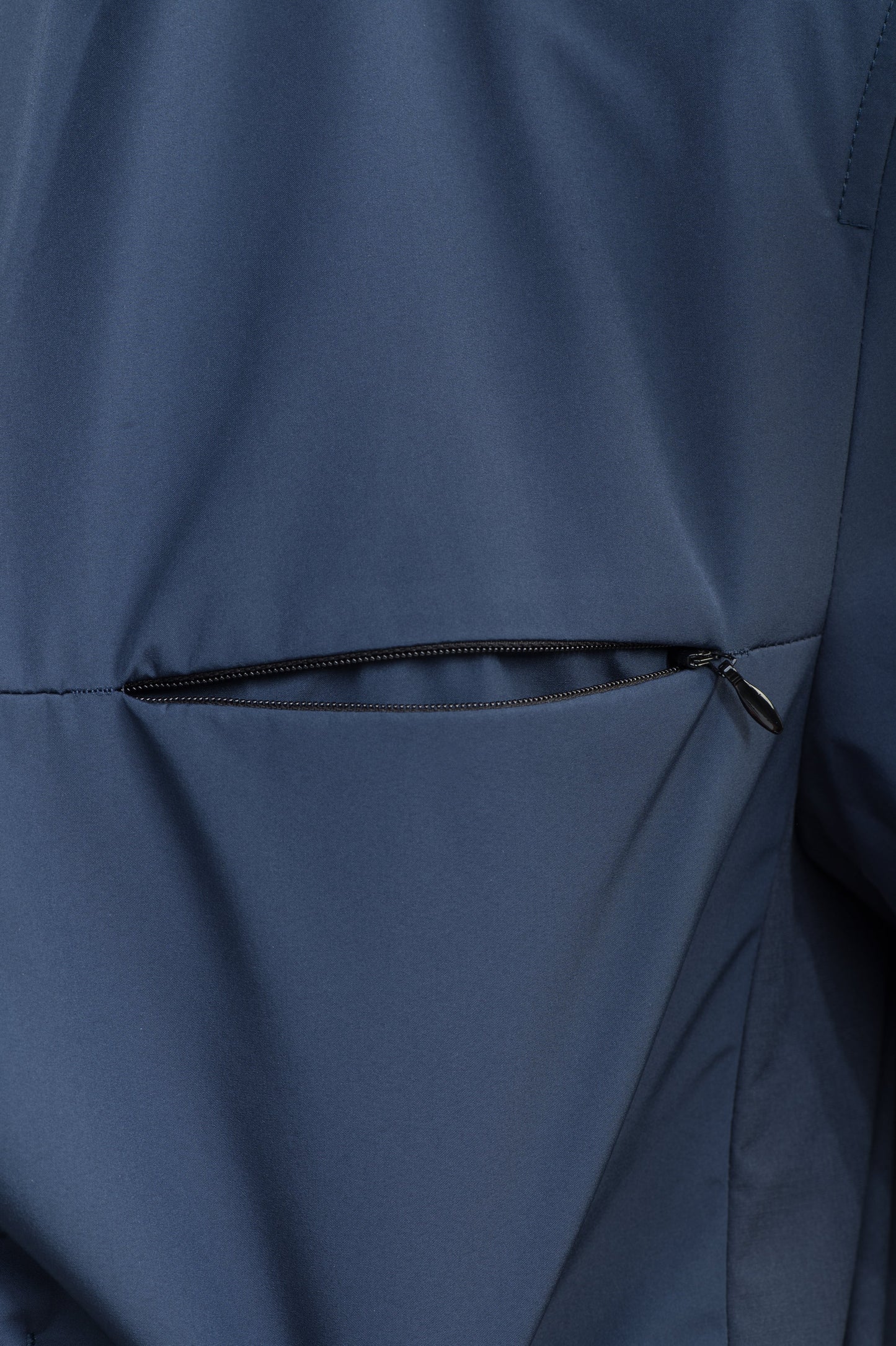 Cody Men's Tailored Travel Blazer in 3-ply micro denier and stretch nylon fabrication with DWR coating, Primaloft Gold Insulation Active+, hidden two-way zipper at centre front with snap closure placket, three invisible exterior zipper pockets, double back pleats, and hidden snap placket at cuffs, in Marine