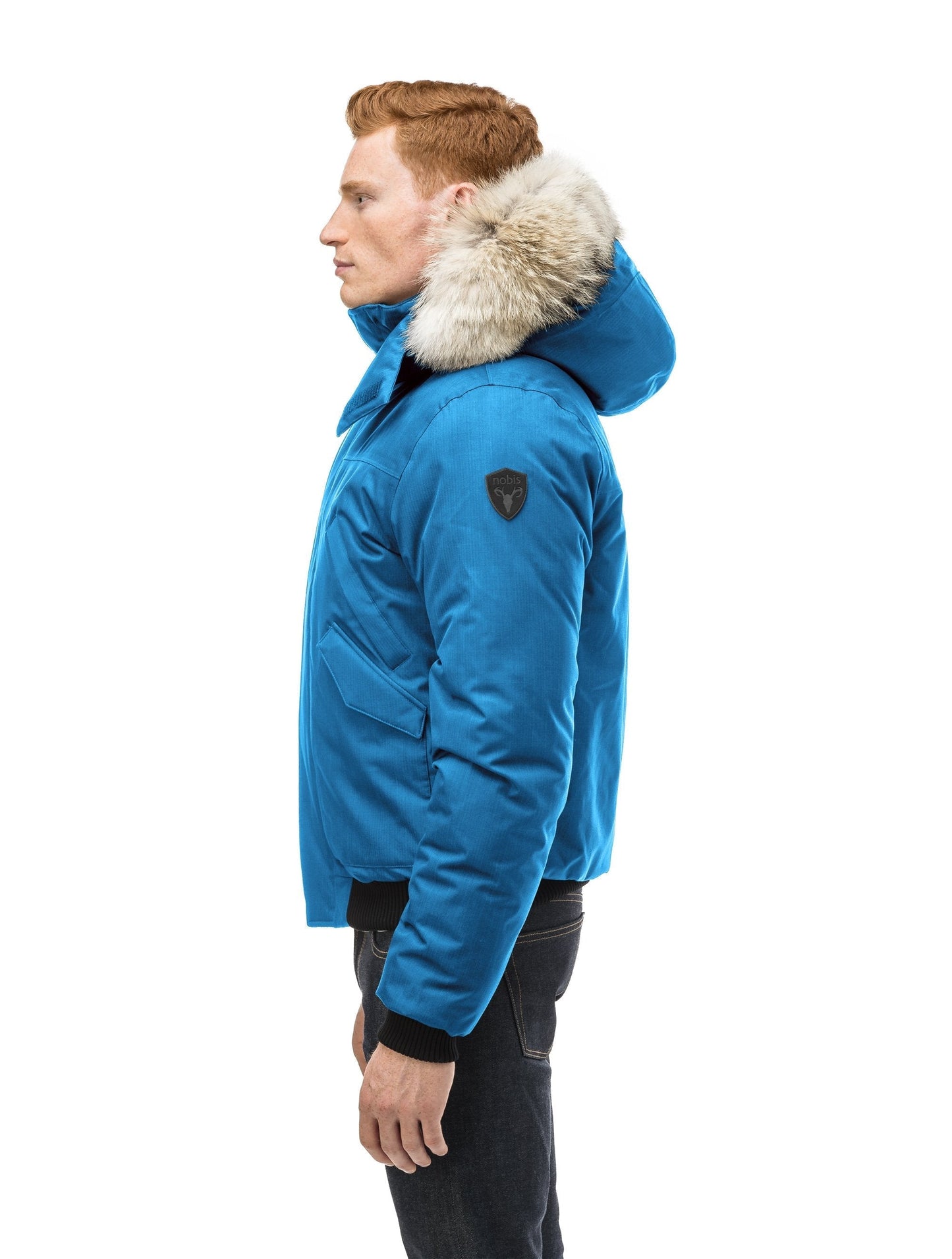 Men's classic down filled bomber jacket with a down filled hood that features a removable coyote fur trim and concealed moldable framing wire in Sea Blue