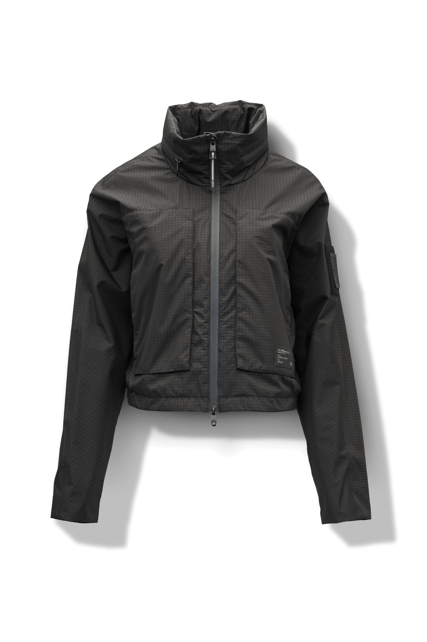 Epsie Women's Cropped Rain Jacket in Black crafted from premium recycled polyester ripstop with a DWR coating and taffeta nylon lining. Features a hidden packaway hood stored in the collar, two-way waterproof front zipper, seam-sealed construction, underarm zip ventilation, adjustable drawcord hem, zippered waist patch pockets, and an interior chest pocket for secure storage. Machine washable. Designed in Canada.