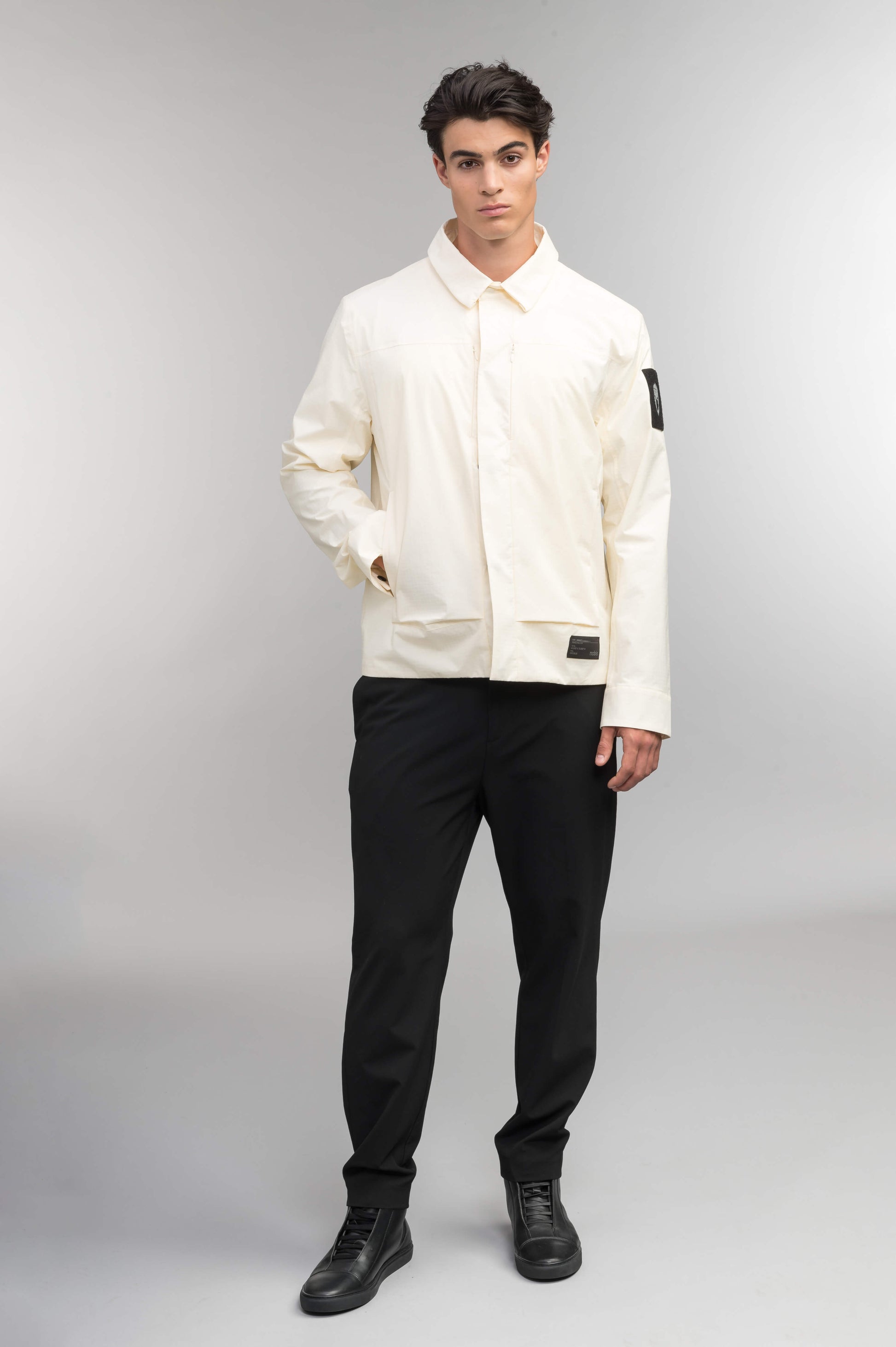 Farson Men's Waterproof Overshirt in Wheat made from premium recycled polyester ripstop with a DWR coating. Features a concealed snap-button front placket, adjustable snap cuffs, invisible chest zip pocket, dual zippered waist pockets, pit zip ventilation, and seam-sealed construction for enhanced weather protection. Designed in Canada.