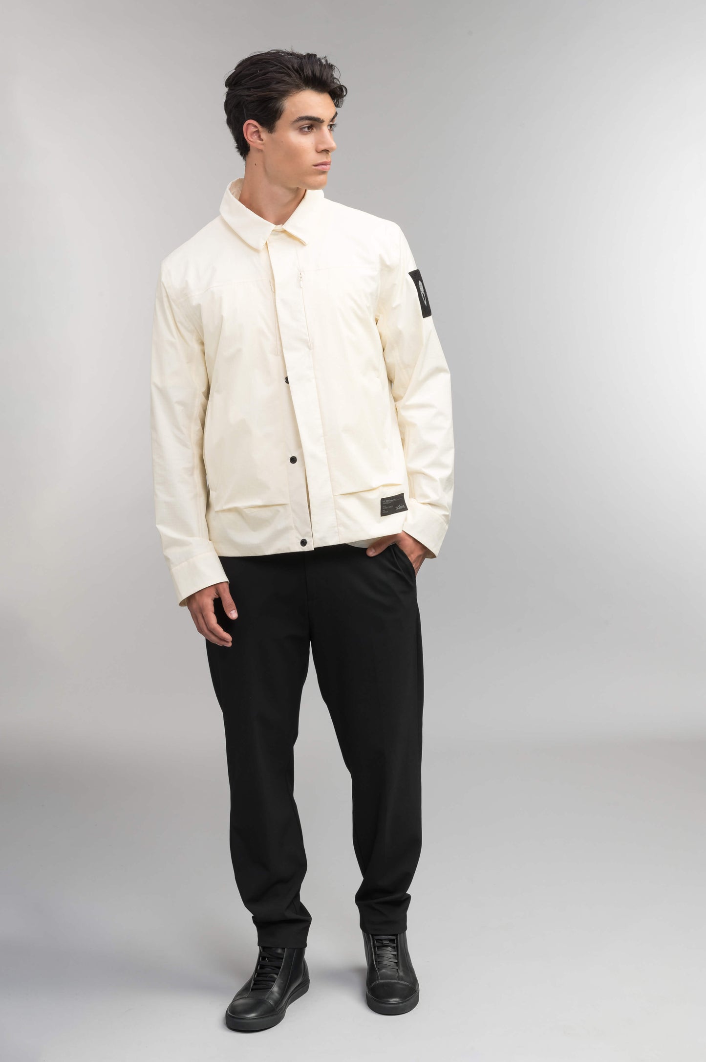 Farson Men's Waterproof Overshirt in Wheat made from premium recycled polyester ripstop with a DWR coating. Features a concealed snap-button front placket, adjustable snap cuffs, invisible chest zip pocket, dual zippered waist pockets, pit zip ventilation, and seam-sealed construction for enhanced weather protection. Designed in Canada.