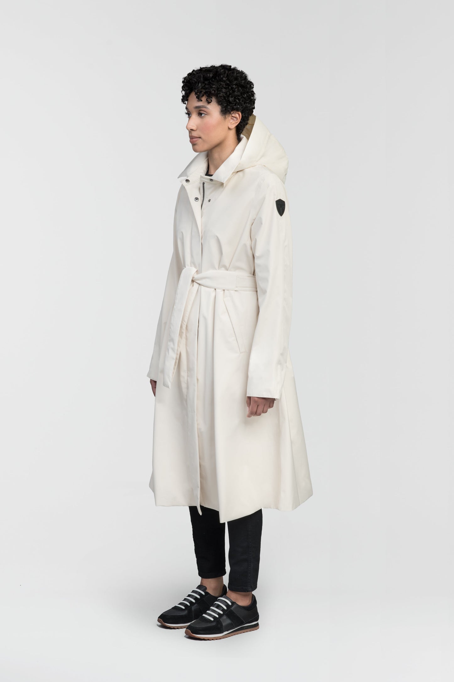 Ivy Ladies Tailored Trench Coat in knee length, 3-Ply Micro Denier fabrication, retractable non-removable hood, front wind flap with snap button closure, removable belt, and adjustable snap cuffs, in Wheat
