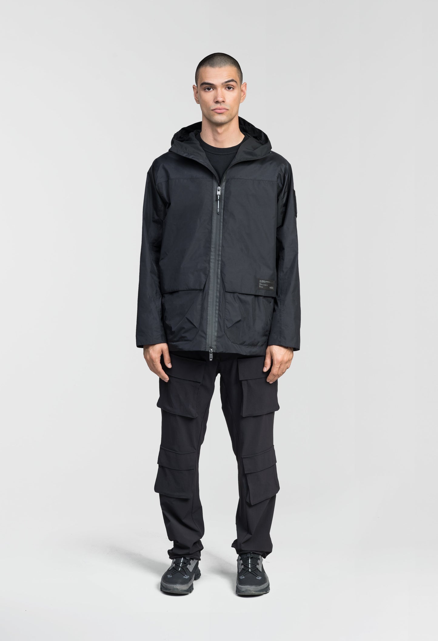 Mission Men's Performance Rain Shell Jacket in hip length, non-removable hood with adjustable toggle, two-way waterproof zipper, flap closure waist pockets with additional side entry storage, zipper ventilation on back, passive underarm ventilation, and breathable mesh lining, in Black