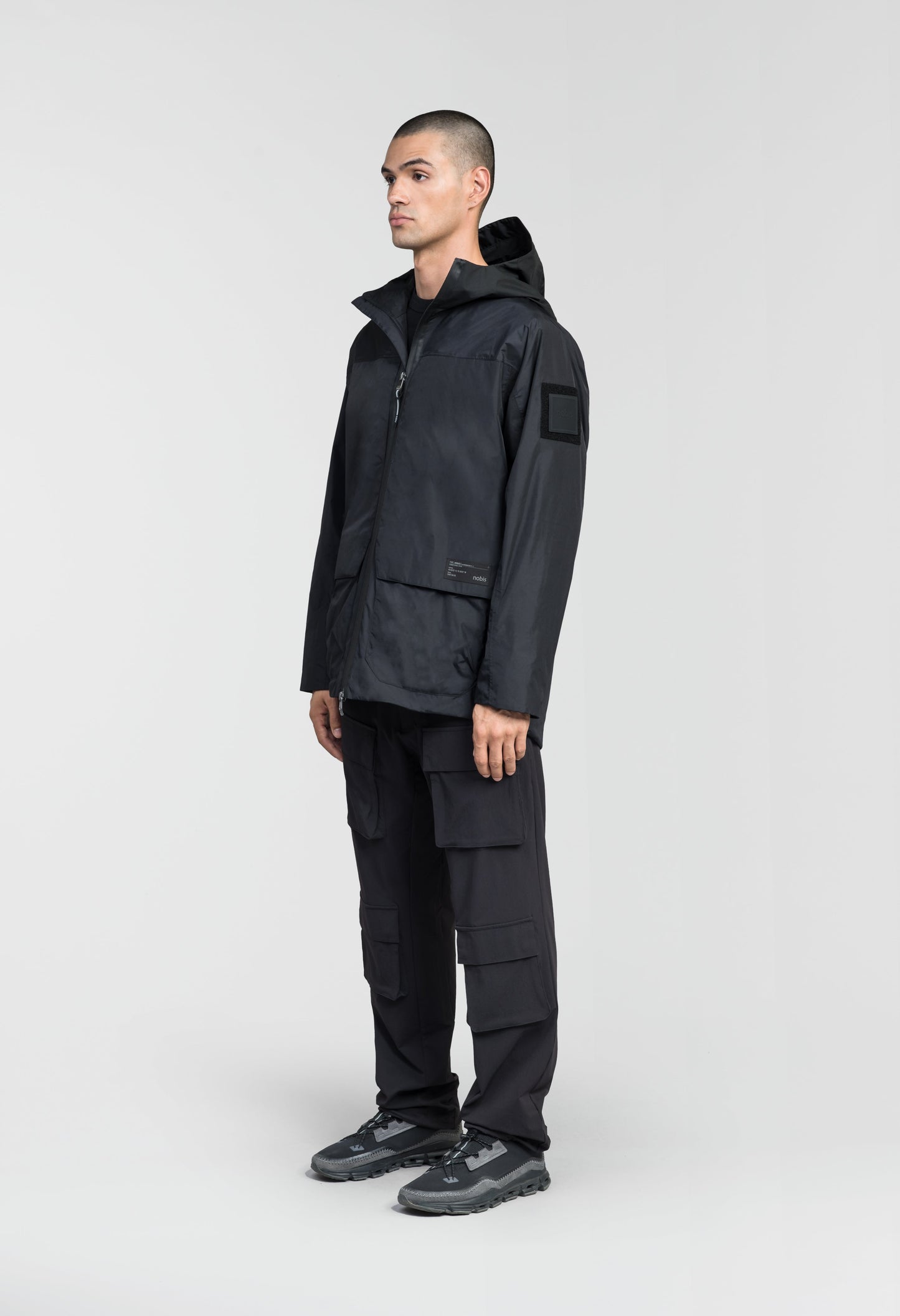 Mission Men's Performance Rain Shell Jacket in hip length, non-removable hood with adjustable toggle, two-way waterproof zipper, flap closure waist pockets with additional side entry storage, zipper ventilation on back, passive underarm ventilation, and breathable mesh lining, in Black