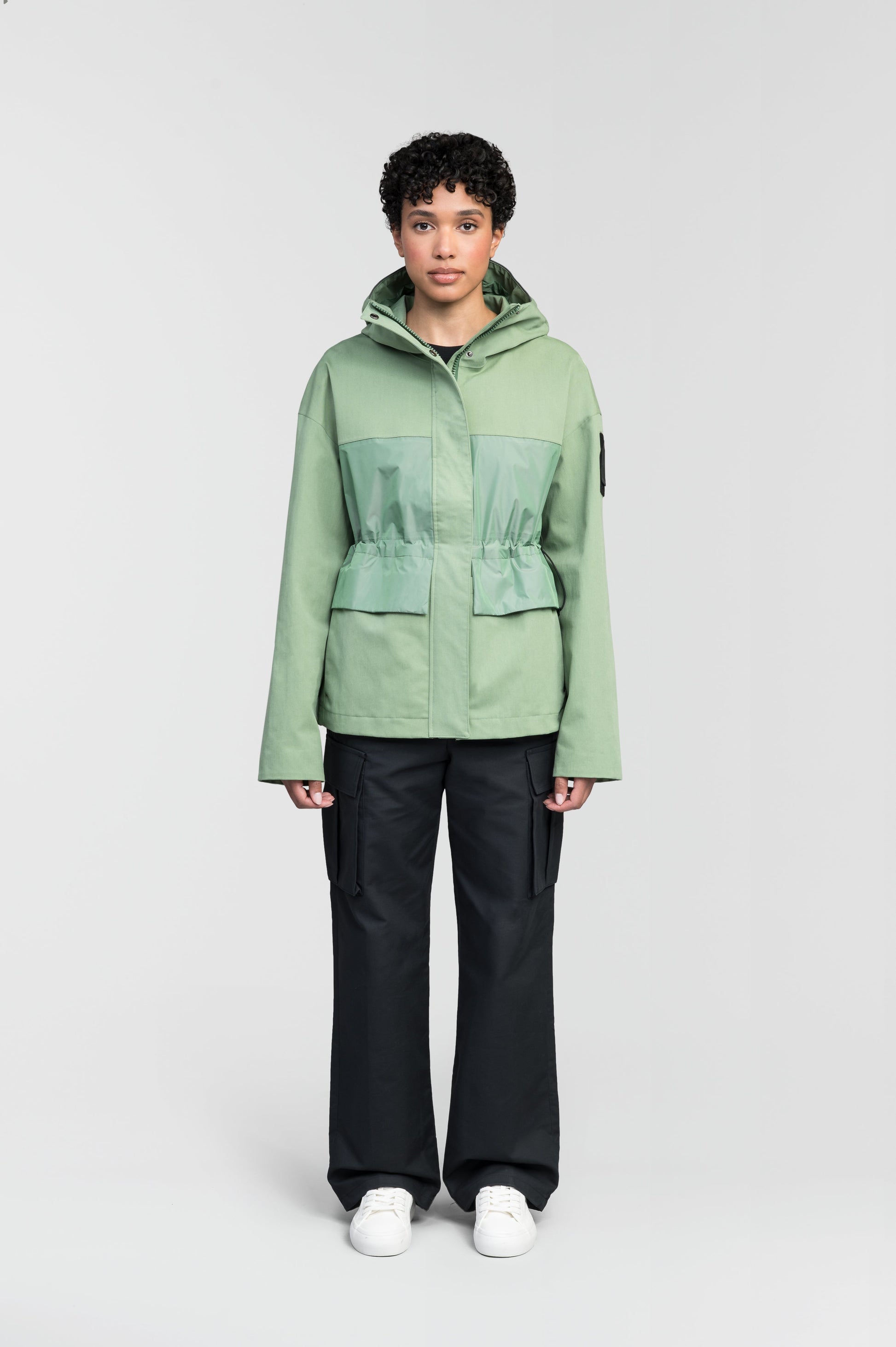 Opal Women's Performance Short Shell Jacket in hip length, premium cotton blend and contrast iridescent fabrication, adjustable drawcord at waist, non-removable hood with reflective trim, adjustable hood draw cord at interior collar, zippered side entry pockets at waist, top entry flap pockets at waist, adjustable snap cuffs, snap button wind flap, two-way branded zipper at centre front, and interior zipper pocket, in Comfrey