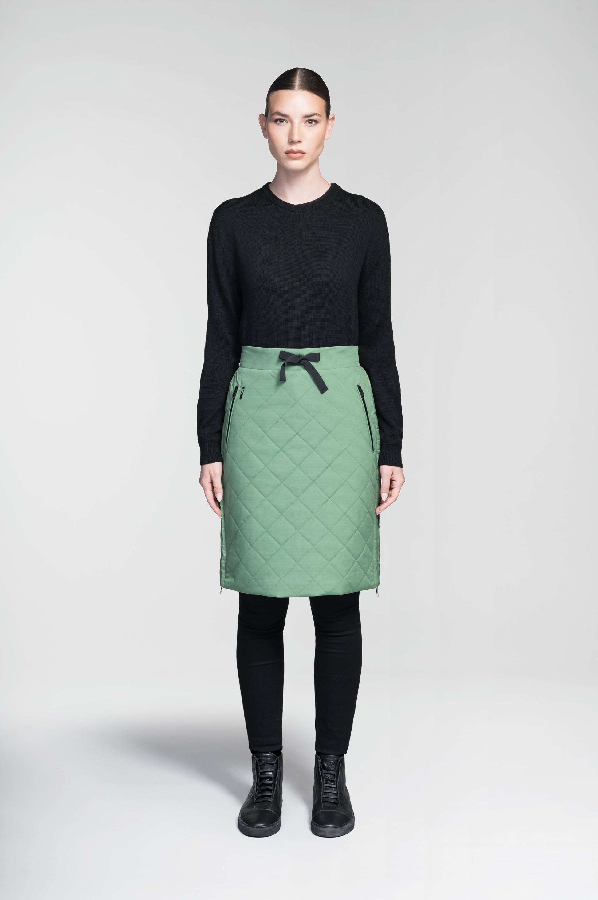 Phora Women's Tailored Skirt in knee length, premium stretch ripstop and contrast cire technical nylon taffeta fabrication, premium 4-way stretch, water resistant Primaloft Gold Insulation Active+, elasticated waistband with grosgrain ribbon drawstrings, two zipper pockets at waist, and zipper closure gusset at side seams, in Comfrey