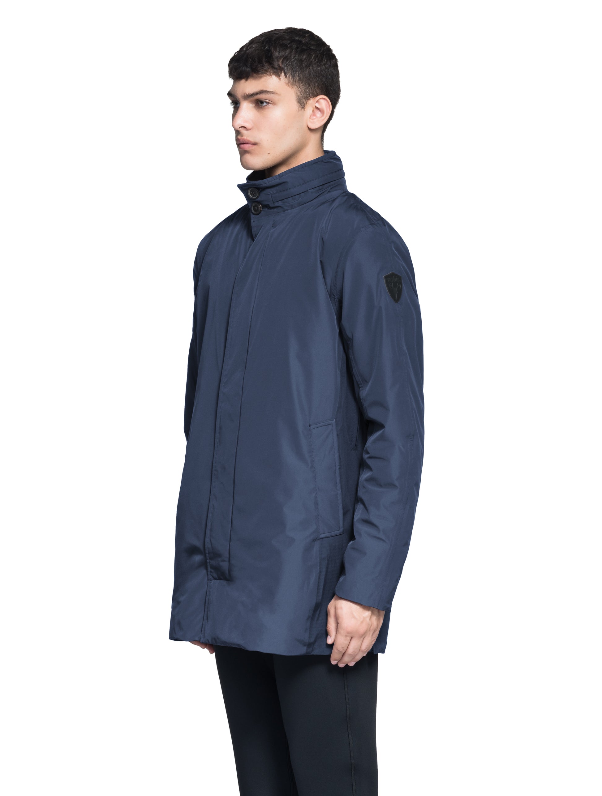 Pike Men's Tailored Mac Coat in thigh length, premium 3-ply Micro Denier fabrication at body and cire technical nylon taffeta fabrication at hood, premium 4-way stretch, water resistant Primaloft Gold Insulation Active+, hidden 2-way zipper with snap closure wind flap, single welt pockets with magnetic closure at waist, hidden snap placket at cuffs, pit zippers for ventilation, interior zipper pocket at right chest, and interior button pocket at left chest, in Marine