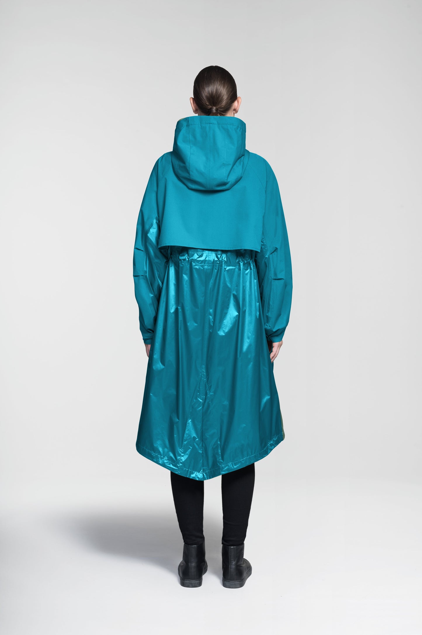 Reyna Women's Tailored Packable Long Shell Jacket in knee length, premium strech ripstop and contrast cire technical nylon taffeta fabrication, non-removable hood with adjustable draw cord, waist flap pockets with magnetic closures, adjustable draw cords at waist and bottom hem, adjustable snap cuffs, mesh back ventilation, hidden packable pocket, snap button wind flap, two-way branded zipper at centre front, adjustable snap button fishtail yoke at back, and large interior zipper pocket, in Deep Lake