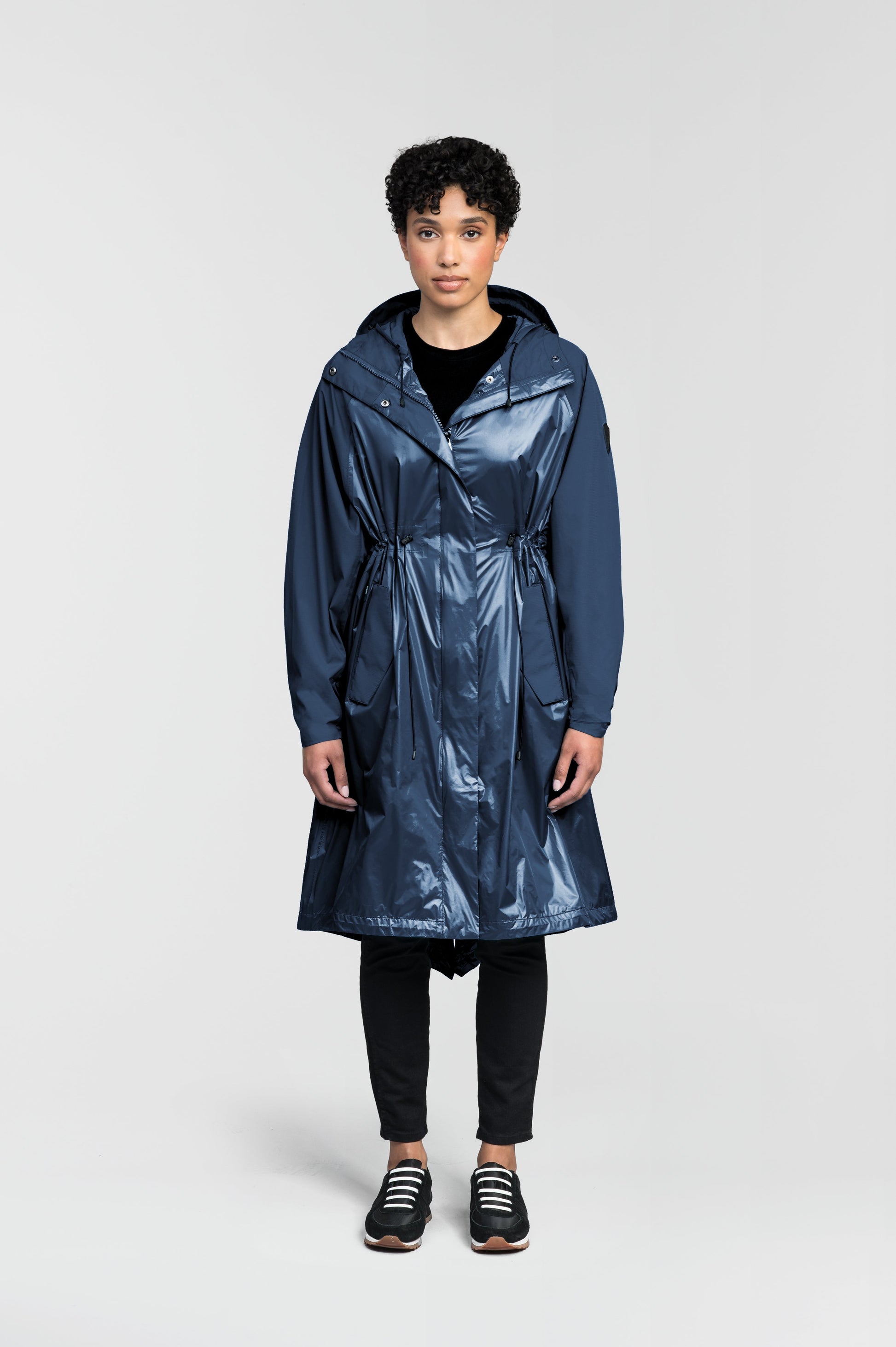 premium strech ripstop and contrast cire technical nylon taffeta fabrication, non-removable hood with adjustable draw cord, waist flap pockets with magnetic closures, adjustable draw cords at waist and bottom hem, adjustable snap cuffs, mesh back ventilation, hidden packable pocket, snap button wind flap, two-way branded zipper at centre front, adjustable snap button fishtail yoke at back, and large interior zipper pocket, in Marine