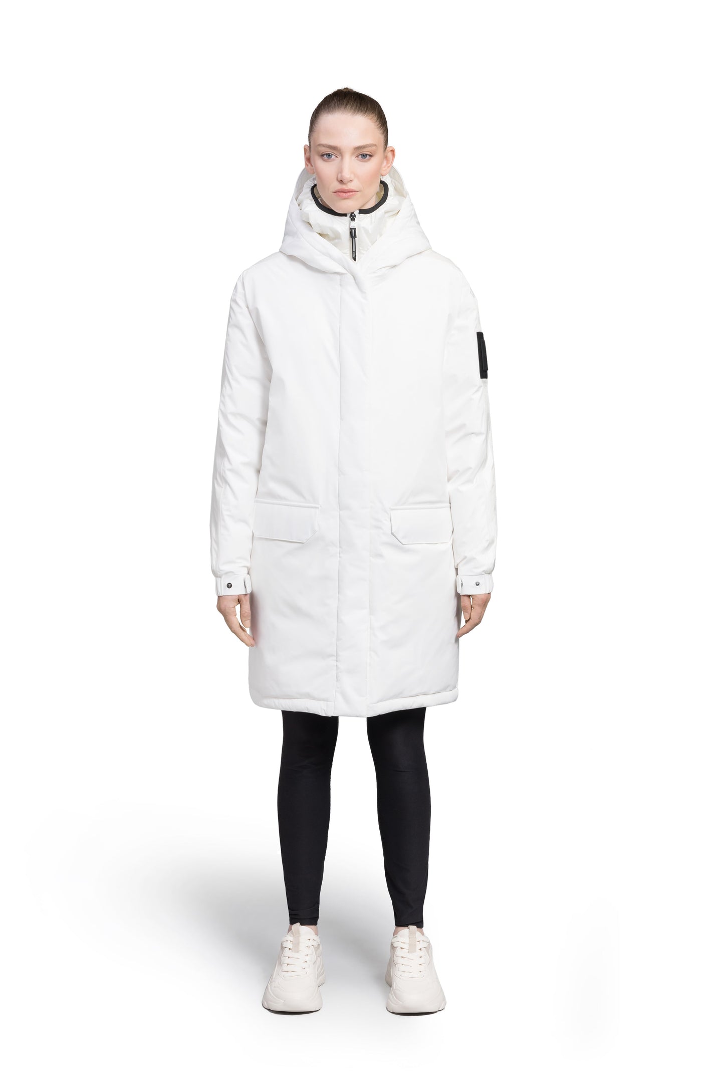 Slyn Women's Performance Parka in thigh length, premium 3-ply micro denier and cire technical nylon taffeta fabrication, Premium Canadian origin White Duck Down insulation, non-removable down-filled hood, inner hooded gilet, two-way centre-front zipper with magnetic closure wind flap, fleece-lined pockets at chest and waist, pit zipper vents, in Chalk