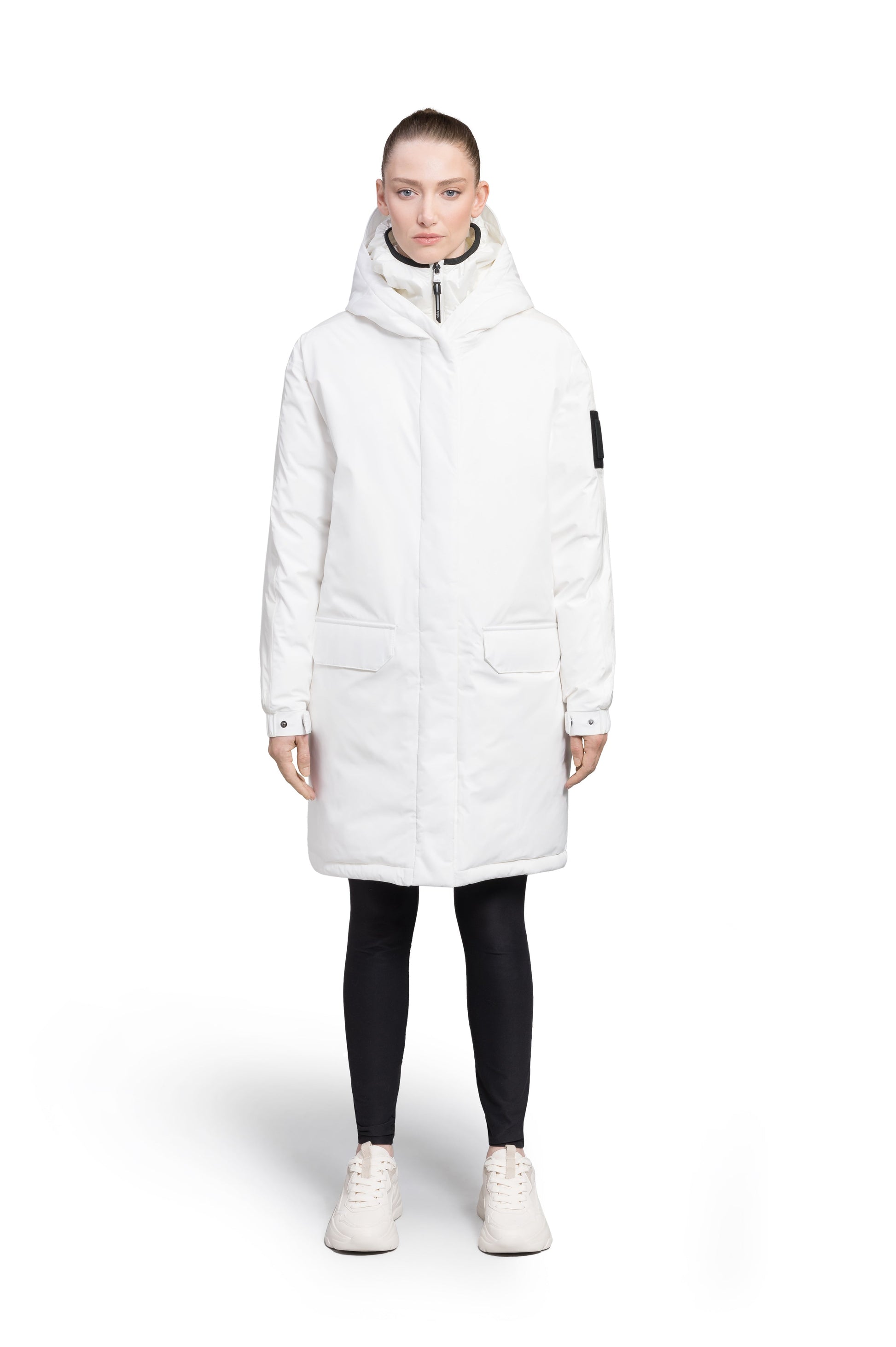 Slyn Women's Performance Parka in thigh length, premium 3-ply micro denier and cire technical nylon taffeta fabrication, Premium Canadian origin White Duck Down insulation, non-removable down-filled hood, inner hooded gilet, two-way centre-front zipper with magnetic closure wind flap, fleece-lined pockets at chest and waist, pit zipper vents, in Chalk