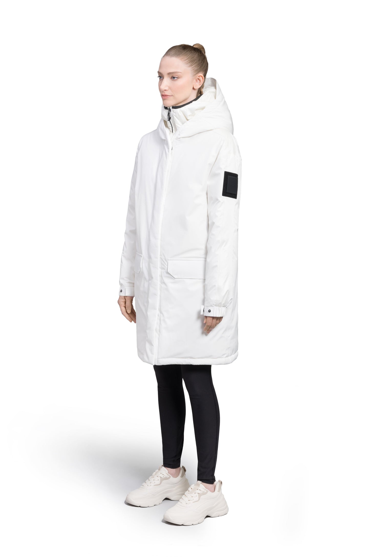Slyn Women's Performance Parka in thigh length, premium 3-ply micro denier and cire technical nylon taffeta fabrication, Premium Canadian origin White Duck Down insulation, non-removable down-filled hood, inner hooded gilet, two-way centre-front zipper with magnetic closure wind flap, fleece-lined pockets at chest and waist, pit zipper vents, in Chalk