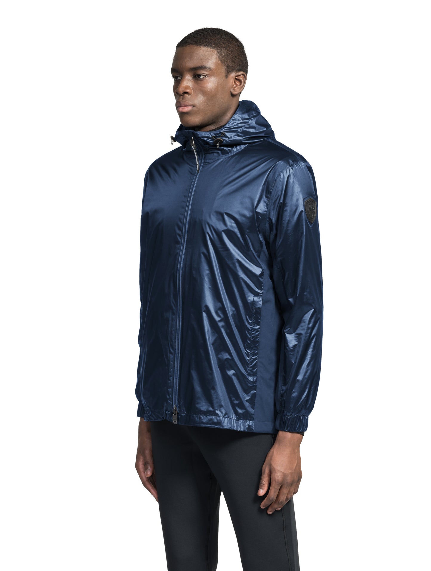 Stratus Men's Tailored Packable Rain Jacket in hip length, premium cire technical nylon taffeta and stretch ripstop fabrication, highly breathable mesh lining, hidden packable pocket, non-removable hood with adjustable draw cord, reflective piping along front and back, underarm grommets for extra breathability, back yoke with mesh ventilation, two waist zipper pockets, two interior zipper pockets, elastic cuffs with adjustable snap button, and adjustable interior draw cord at waist hem, in Marine