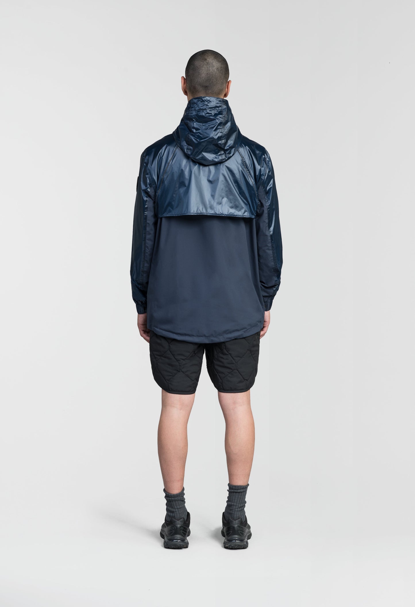 Stratus Men's Tailored Packable Rain Jacket in hip length, premium cire technical nylon taffeta and stretch ripstop fabrication, highly breathable mesh lining, hidden packable pocket, non-removable hood with adjustable draw cord, reflective piping along front and back, underarm grommets for extra breathability, back yoke with mesh ventilation, two waist zipper pockets, two interior zipper pockets, elastic cuffs with adjustable snap button, and adjustable interior draw cord at waist hem, in Marine