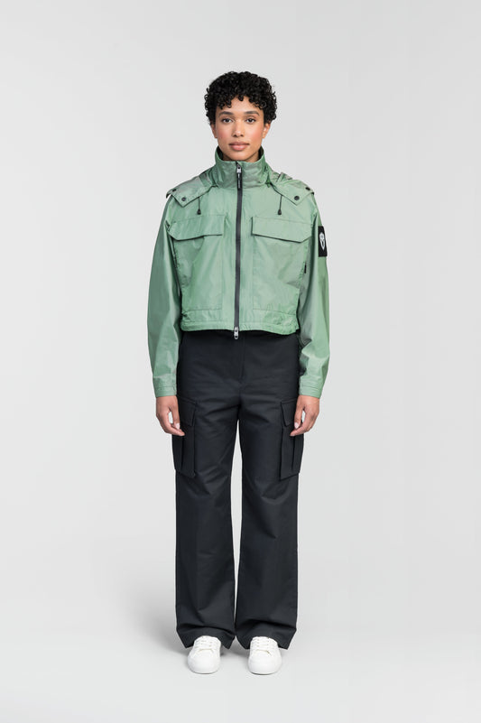 Viva Women's Performance Cropped Jacket in waist length, premium iridescent fabrication, removable hood with peak, adjustable hood draw cords and toggle, 2-way branded zipper at centre front, oversized magnetic closure flap pockets at chest with side entry, interior adjustable draw cord at hem, large interior zipper pocket, and adjustable snap cuffs, in Comfrey + Comfrey / XS