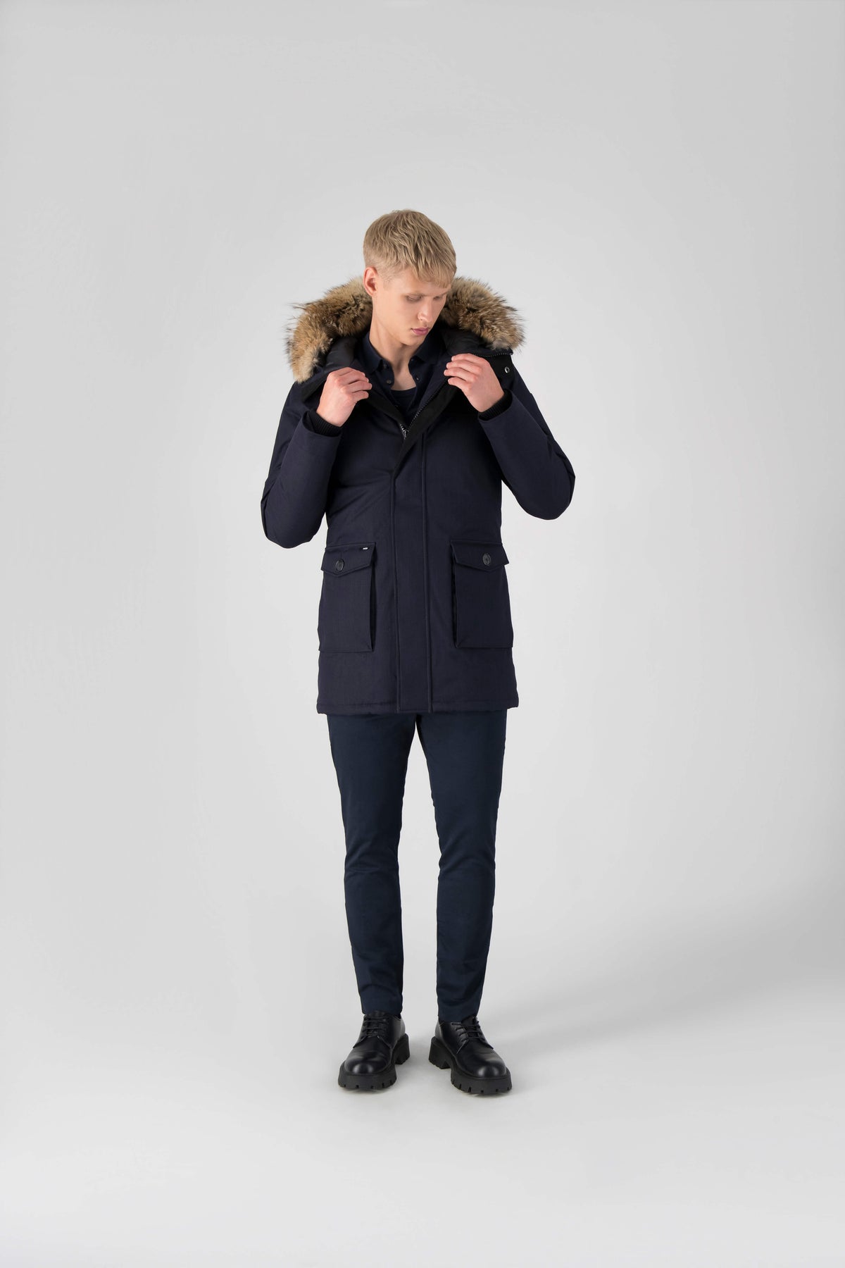 Men's slim fitting waist length parka with removable fur trim on the hood and two waist patch pockets in Navy