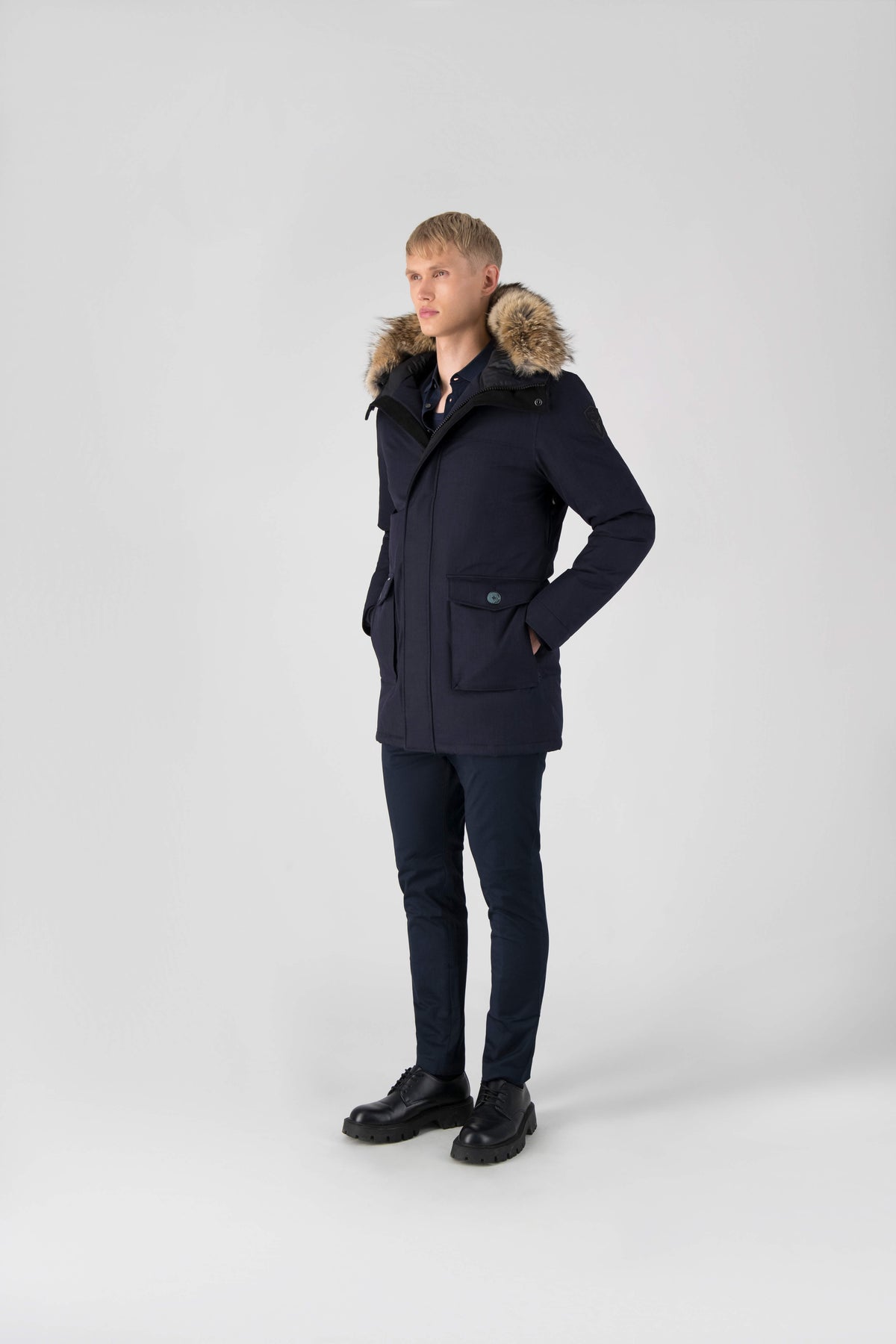 Men's slim fitting waist length parka with removable fur trim on the hood and two waist patch pockets in Navy